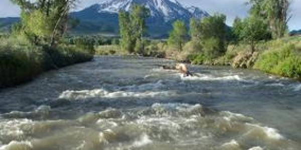 With Colorado's Mount Sopris in the background, water flows along the Roaring Fork River