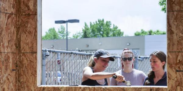 Students stand outside a pocket studio and talk. 