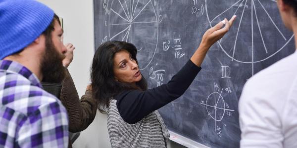 Teacher writing on a blackboard in the classroom