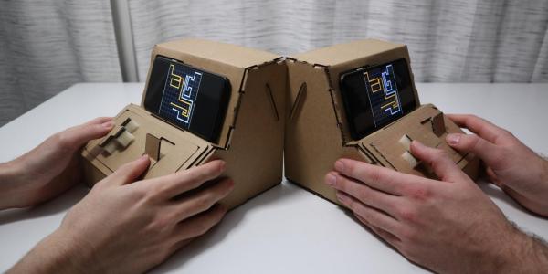 people playing with Tinycade cardboard controllers