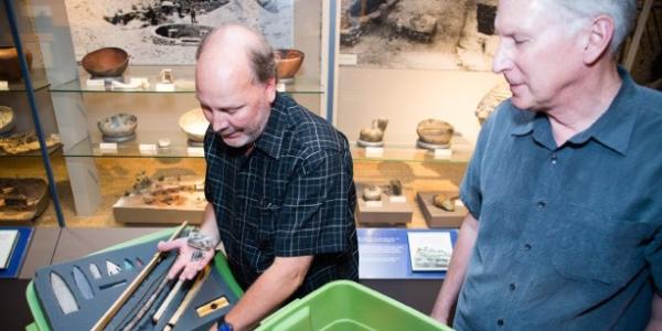 Senior museum educator Jim Hakala, left, and anthropology curator Steve Lekson prepare a fossil kit to be delivered to a Colorado classroom. 
