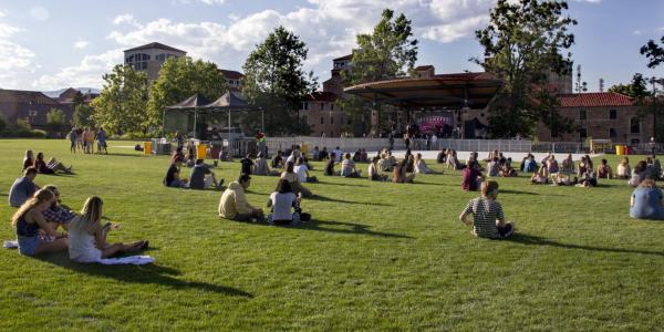 Students sit on Farrand Field lawn to watch a concert