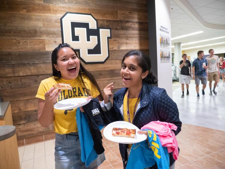 Students eating pizza during Connect at The Rec event in 2018