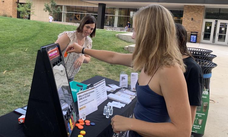 Anna Brennan, left, interacts with students visiting the Office of Victim Assistance Table during Fall 2021 Move-In. (Photo provided)