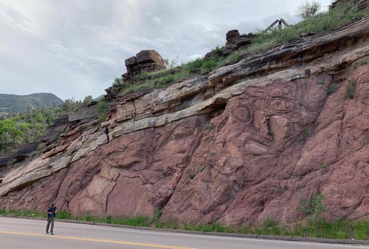 A hiker walks past one site of the Great Unconformity near the town of Manitou Springs, Colorado.