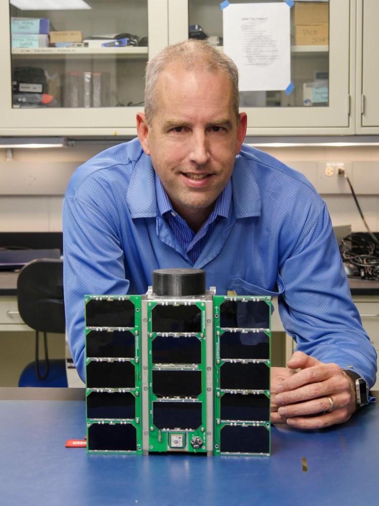 Scott Palo with a small satellite known as a CubeSat