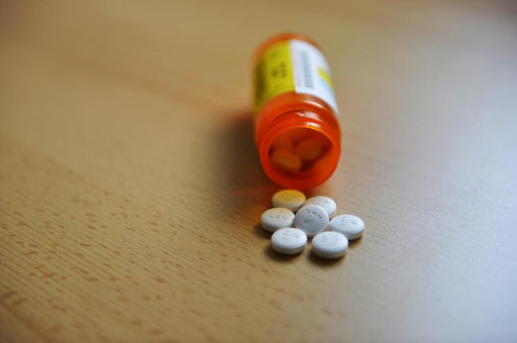 White pills spill out of prescription bottle