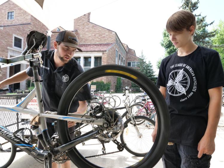 Max Robbins, a senior environmental science major from Grand Junction (left) and Thrombin Atwell-Donaghey, a sophomore chemistry major from Boulder tune a bike at the UMC bike station at the University of Colorado Boulder.
