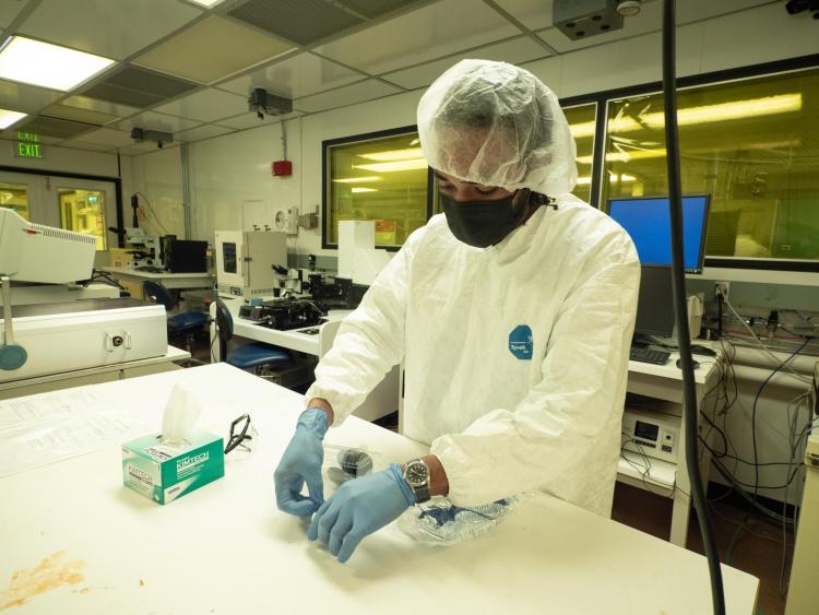 Engineer wearing a mask and cap working in cleanroom at COSINC