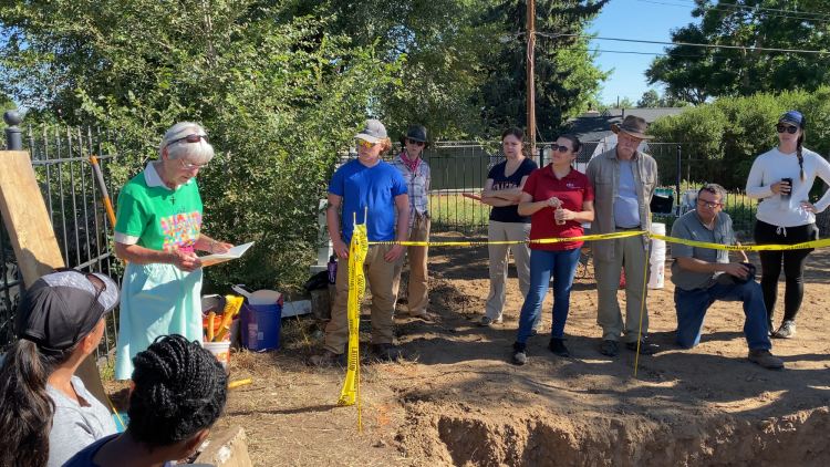 Sister Mary Nelle Gage reads to a crowd of people outdoors