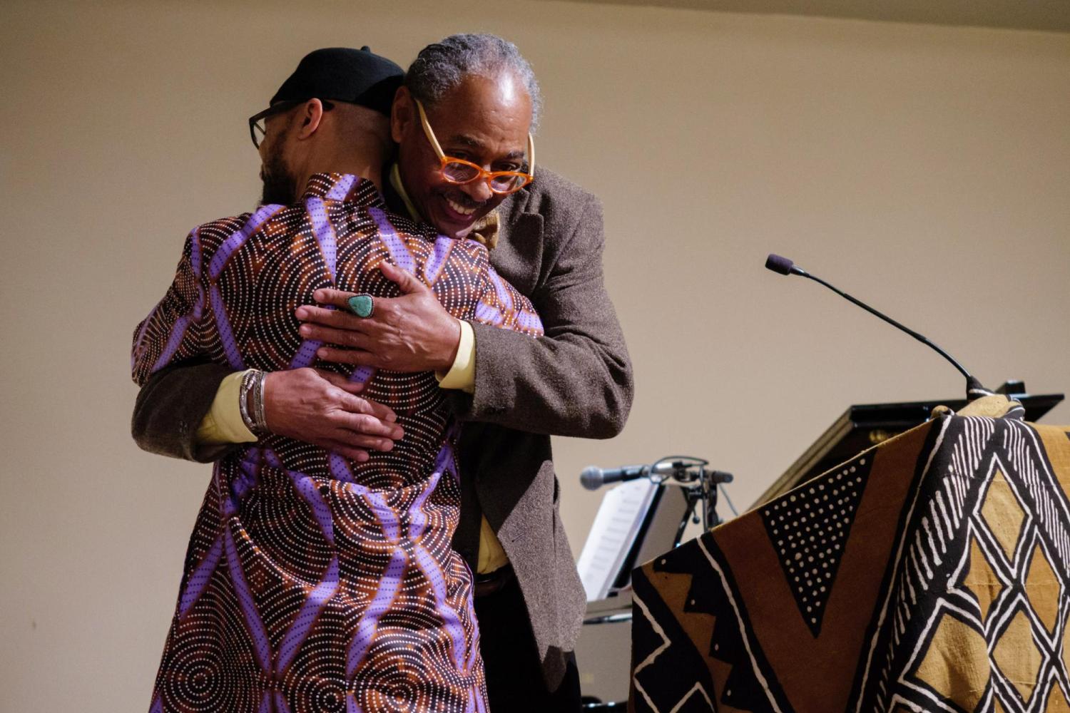 Thomas Windham and Reiland Rabaka embrace as Rabaka takes the stage after being introduced by Windham. (Glenn Asakawa/University of Colorado)