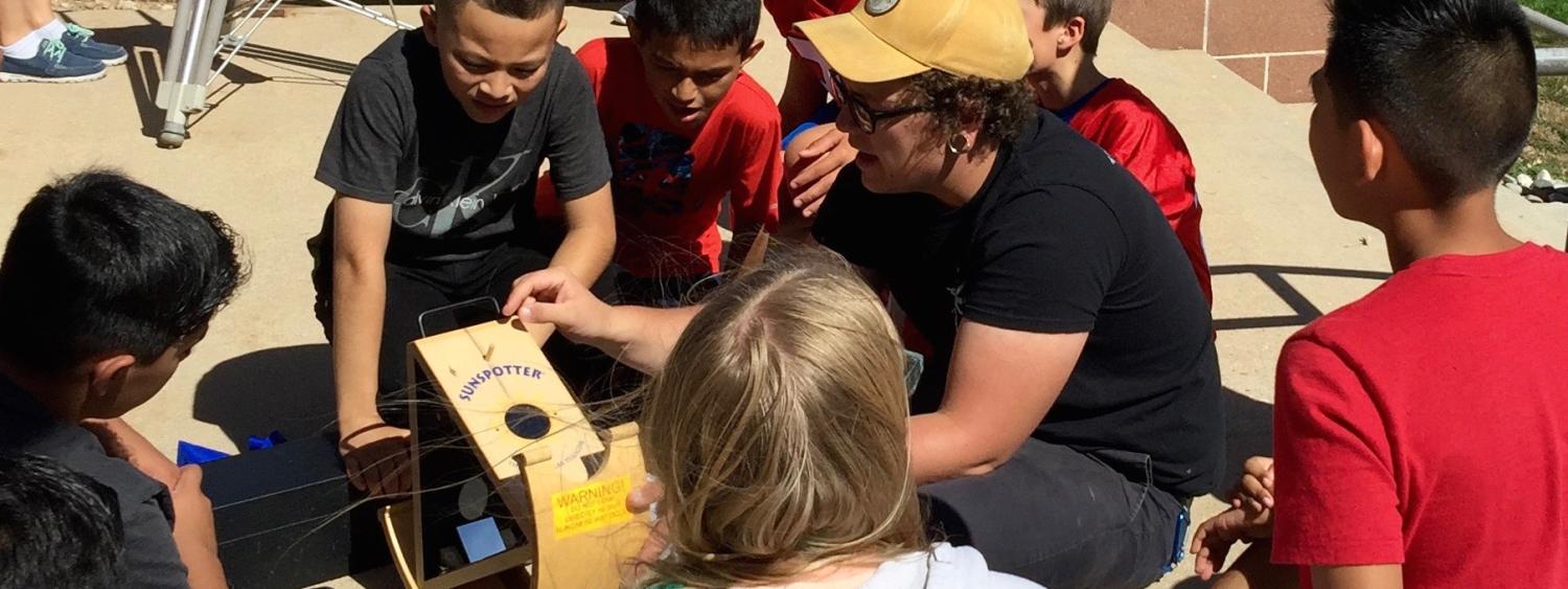 CU Boulder astronomy and physics student Sam Strabala searches for sunspots with middle schoolers in Keenesburg, Colorado as part of a science outreach program.