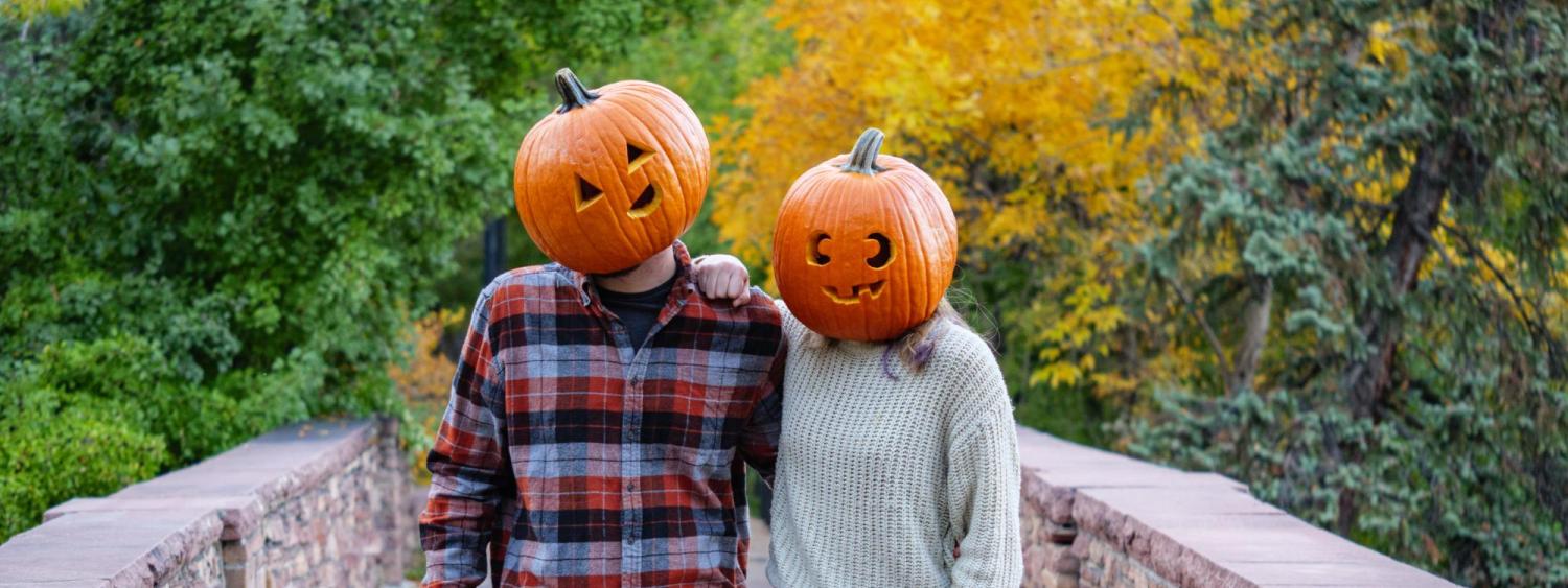 Students Mackenzie Hernandez and Nathan Smith don jack-o-lanterns on their heads