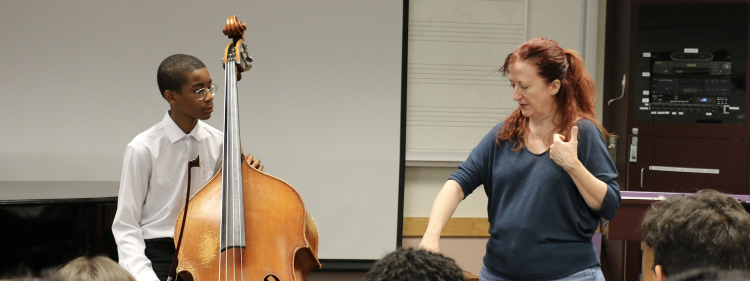 instructor working with student playing an upright bass