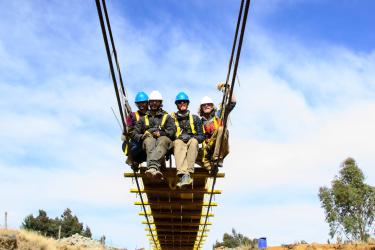 CU Boulder engineering students sit on suspension bridge
