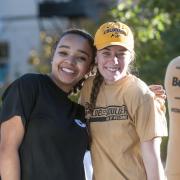 Two friends embrace for a photo at the 2014 Homecoming parade