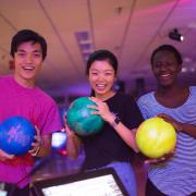 Students pose with bowling balls at The Connection bowling alley