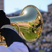 Gold Buff Marching Band member plays marching euphonium during Homecoming game