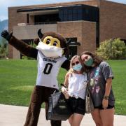 Student and parent pose for a photo with Chip the mascot during move-in