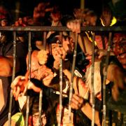 Horde of zombies attempts to break through metal gate
