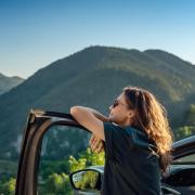 person traveling by car in the mountains during summer vacation