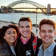 Three students take a photo by the Harbour Bridge in Sydney, Australia