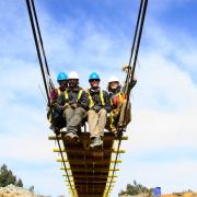 CU Boulder engineering students sit on suspension bridge