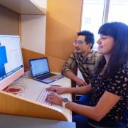 Woman types on computer keyboard while a man looks at the monitor