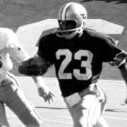 Black and white photo of Cliff Branch running football
