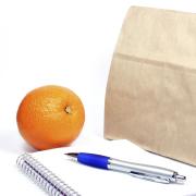 Brown bag, pen, notepad and orange