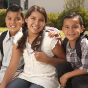Two brothers and sister ready for school with backpacks on | Photo credit BUENO Center