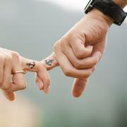 A couple holding hands with matching tattoos