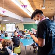 Ricardo Reyes takes air quality measurements from the back of a classroom filled with kids