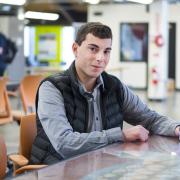 David Meyer holds his phone to display the Flatiron Chat app on screen