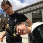 CU-STARs student volunteer helps child look through telescope
