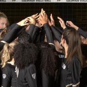 Colorado women's volleyball players stand in a huddle