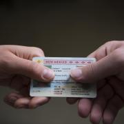 Person hands over drivers license