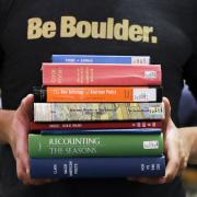 Campus community members holds stack of poetry books