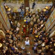 Ukrainians stand over a casket in a church