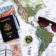 laydown of map, passport, sunglasses, travel brochure