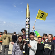 Students standing near a research rocket that they built.