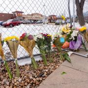 Flowers line a fence surrounding the parking lot where 10 adults, including a police officer, were shot by a lone gunman at the King Soopers at 3600 Table Mesa Dr. (Photo by Glenn Asakawa/University of Colorado)