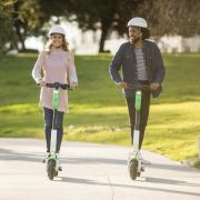Two people riding Lime scooters