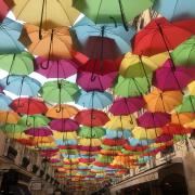 Colorful umbrellas cover a Paris street