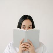 Person with a book in front of her face