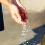 Fresh water pouring into a person's hands