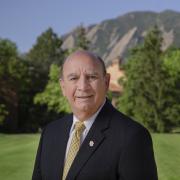 Chancellor Phil DiStefano stands in front of the Flatirons