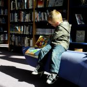 Child reads a book in the library