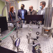 Margaret Murnane, U.S. Rep. Joe Neguse, Philip DiStefano and Todd Saliman inspect equipment in a lab
