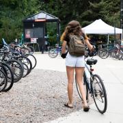 Student walking their bike toward a rack on campus